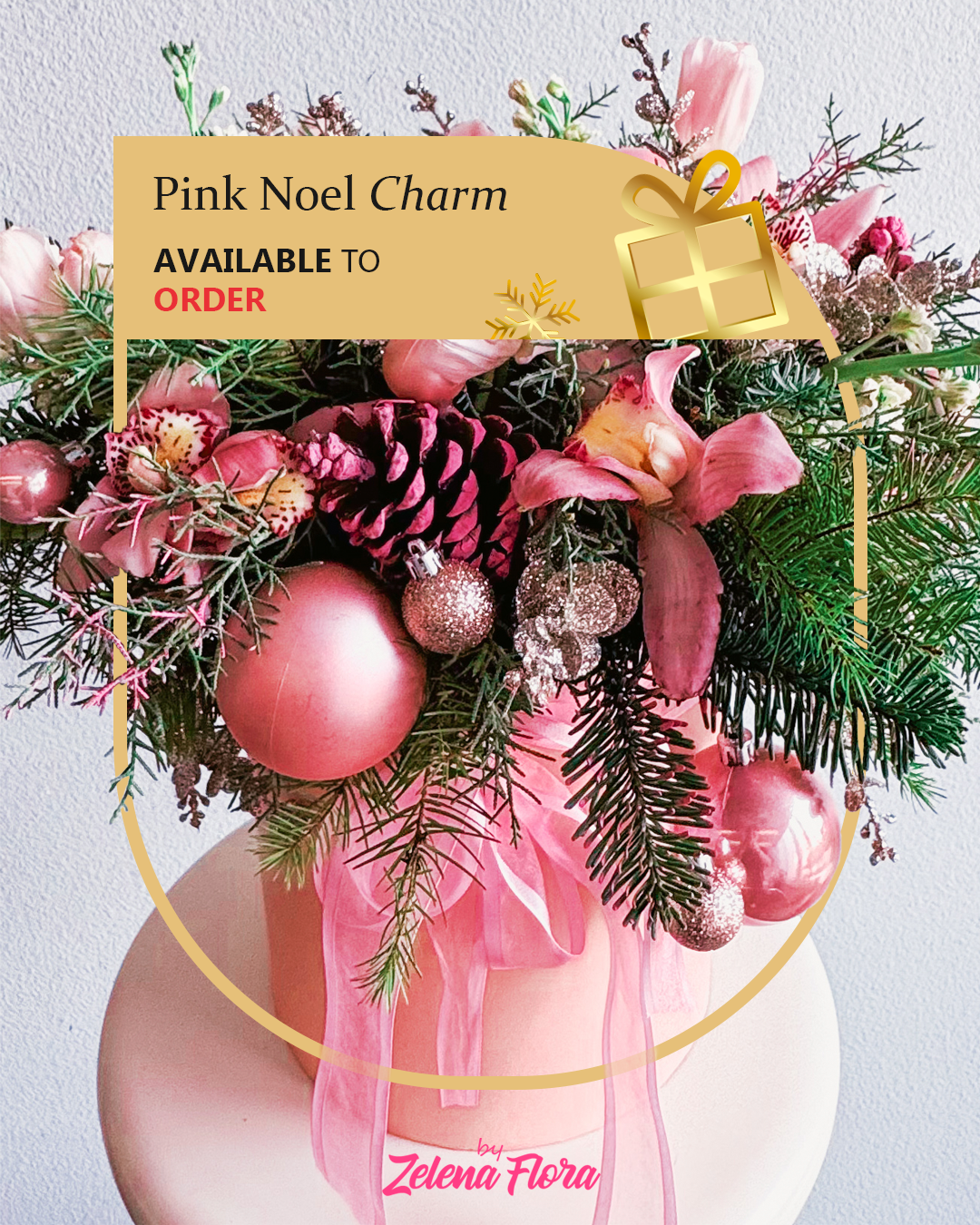 Decorative arrangement with pink ornaments and greenery, featuring a 'Pink Noel Charm' label.