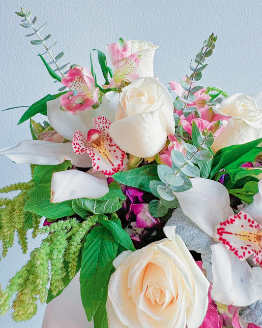 Blush Bliss flower box arrangement with creamy white roses, pink orchids, hydrangeas, dusty miller leaves, alstroemerias, and trailing amaranthus by Zelena Flora