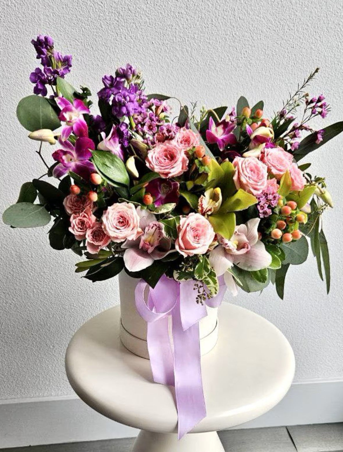 First Date floral box arrangement with blush roses, orchids, purple stock, eucalyptus, and lavender ribbon by Zelenaflora in Los Angeles