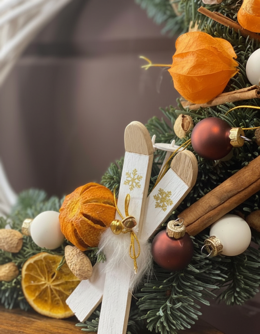 Decorative Christmas tree with ornaments including cinnamon sticks, dried oranges, and gold ribbons.