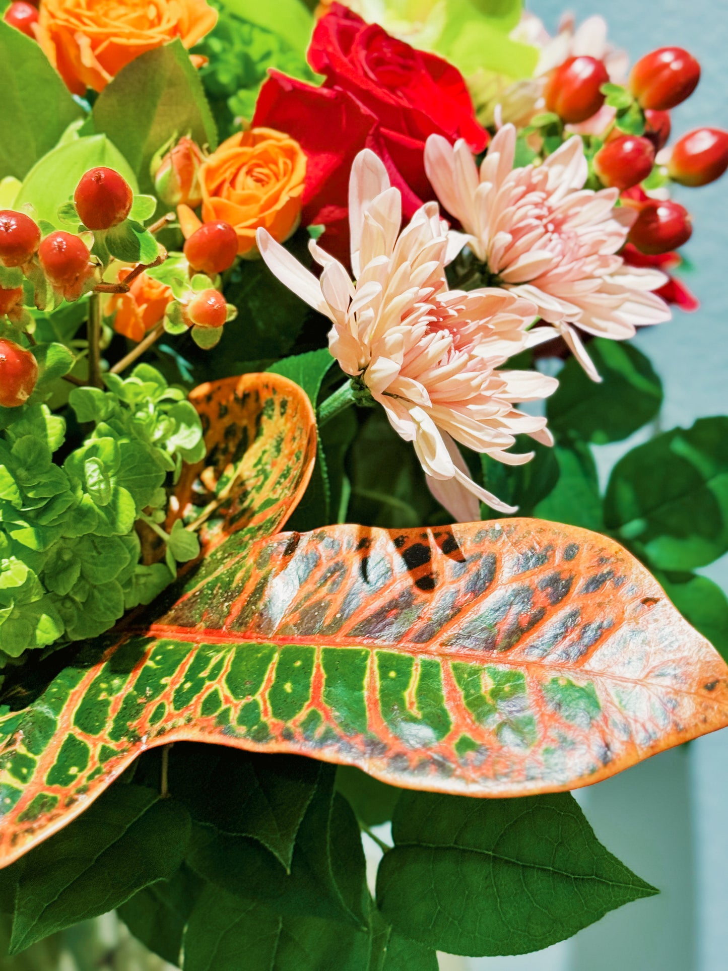 Colorful bouquet of flowers with a large leaf in the foreground