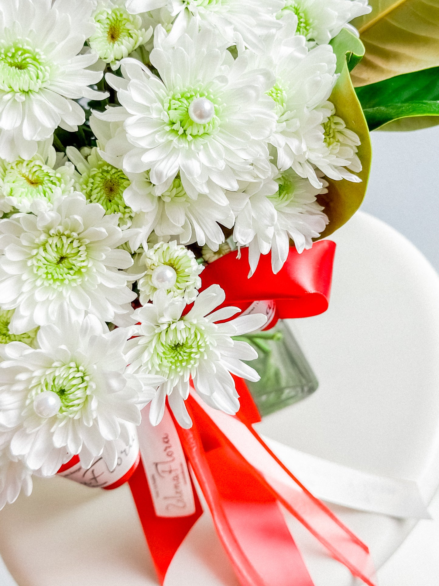 Minimalist romantic flower arrangement in vase—white chrysanthemums with red rose focal bloom