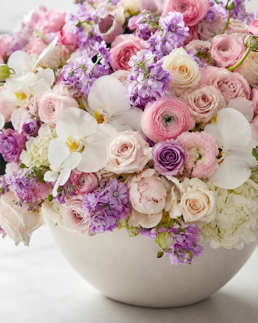 Close-up of Rose Garden arrangement with pink ranunculus, blush roses, white orchids, lavender stock flowers, hydrangeas, and soft greenery | Zelena Flora | Los Angeles