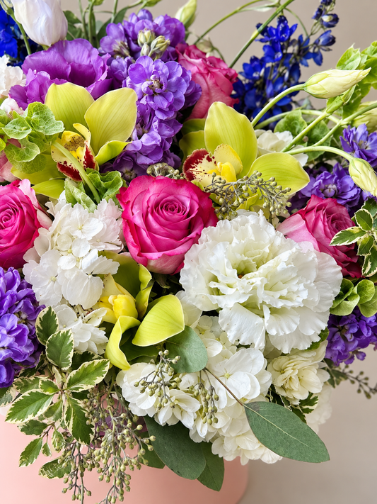Close-up of English Garden flowers with pink roses, white hydrangeas, yellow-green cymbidium orchids and purple stock