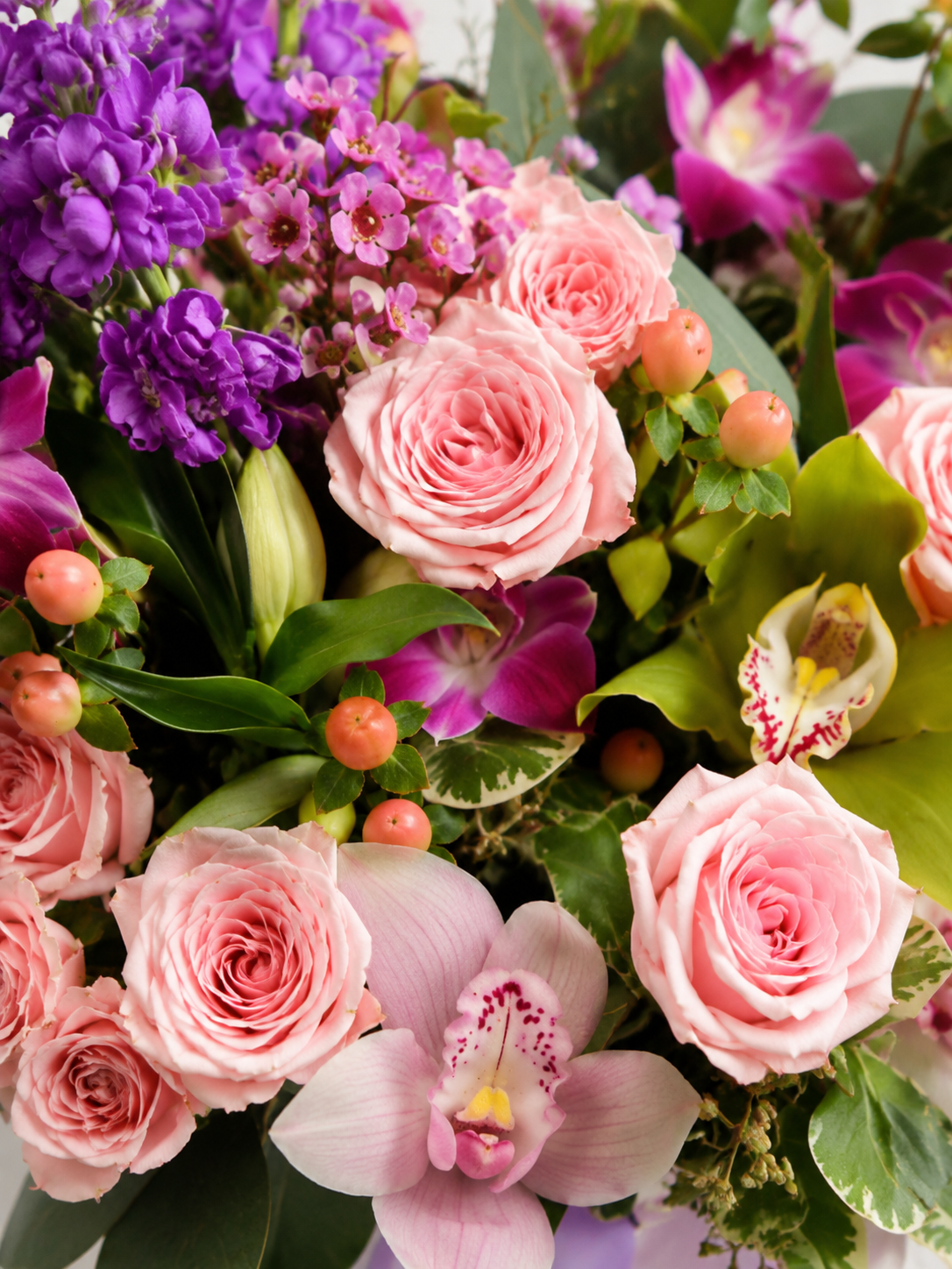 Close-up of First Date arrangement with blush roses, purple orchids, stock flowers, eucalyptus, and peach hypericum berries | Zelena Flora | Los Angeles