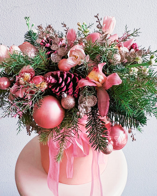 Decorative floral arrangement with pink ornaments and ribbons on a white background