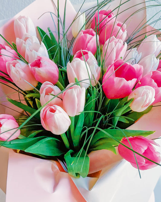 Pretty in Pastels tulip bouquet with soft pink and vibrant magenta tulips, pastel wrapping, and wispy greenery by Zelena Flora