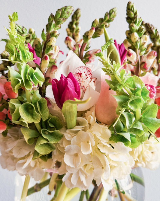 Rose Emerald elegant flower bowl with white hydrangeas, pink tulips, blushing berries, snapdragons, and bells of Ireland by Zelena Flora