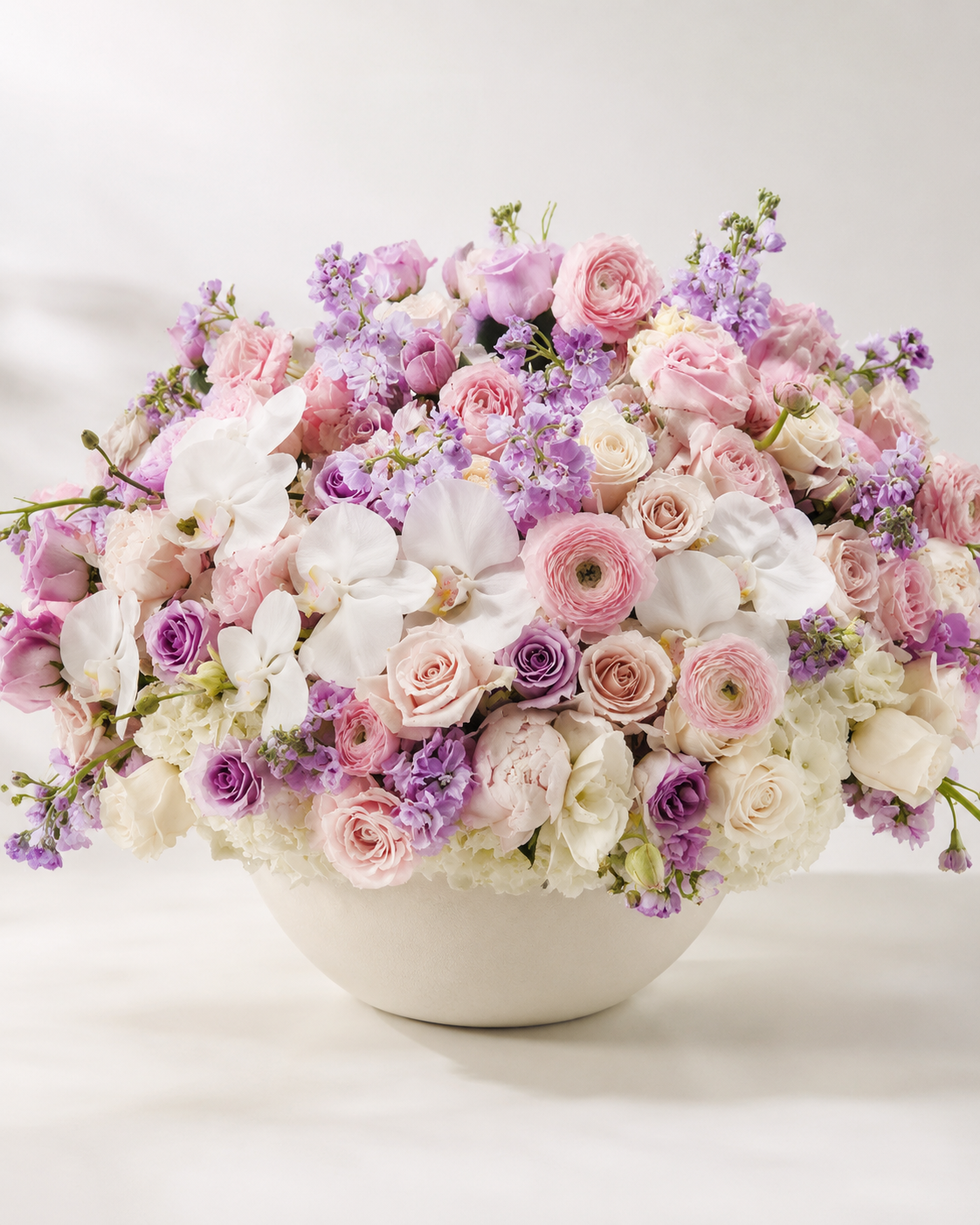 Rose Garden luxury floral arrangement in a wide off-white ceramic bowl with pink roses, white orchids, ranunculus, lisianthus, hydrangeas, and greenery | Zelena Flora | Los Angeles