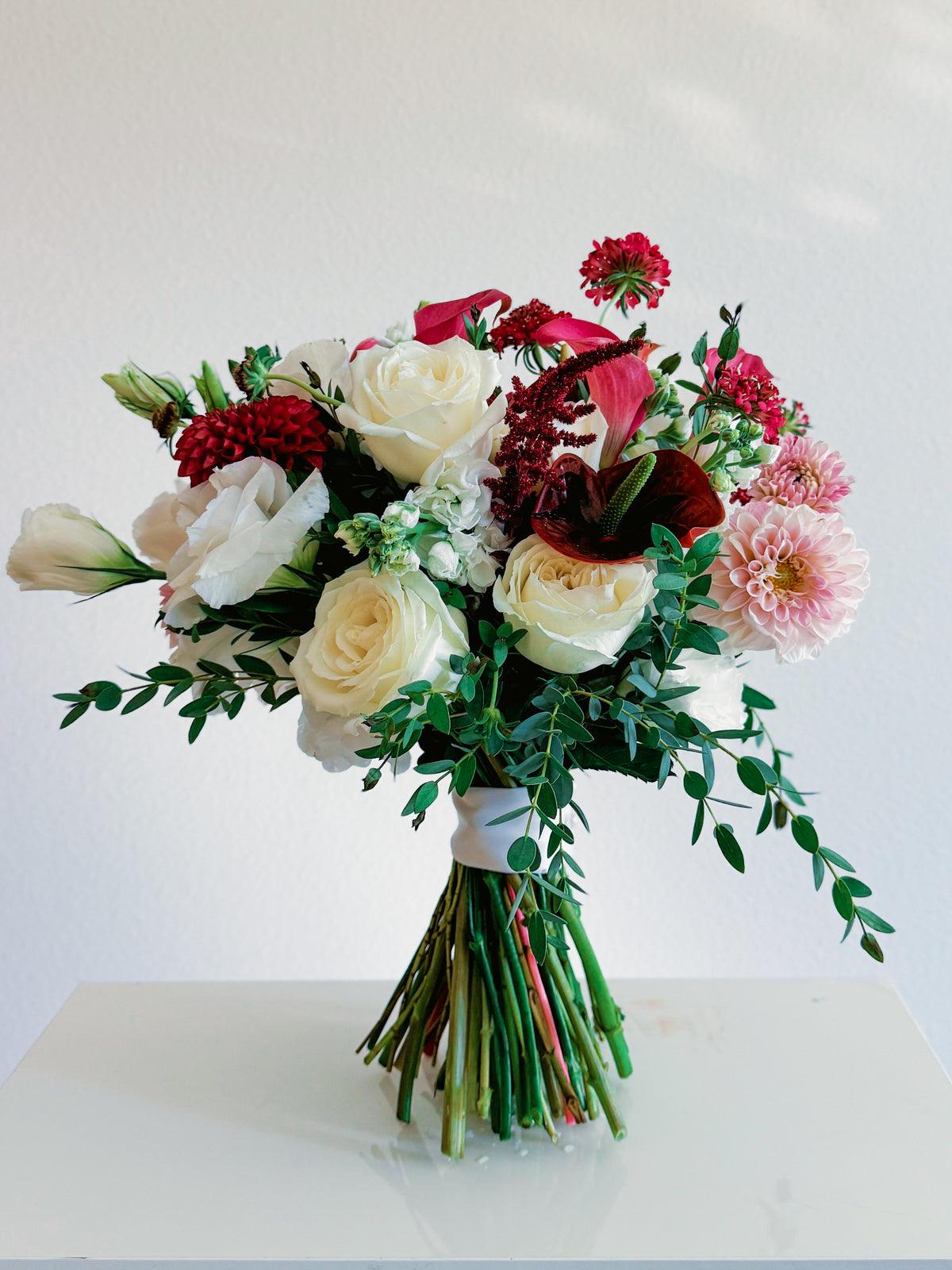 Passion Promise hand-tied bouquet with ivory roses, burgundy and blush dahlias, mauve calla lilies, anthurium and greenery | Zelena Flora | Los Angeles