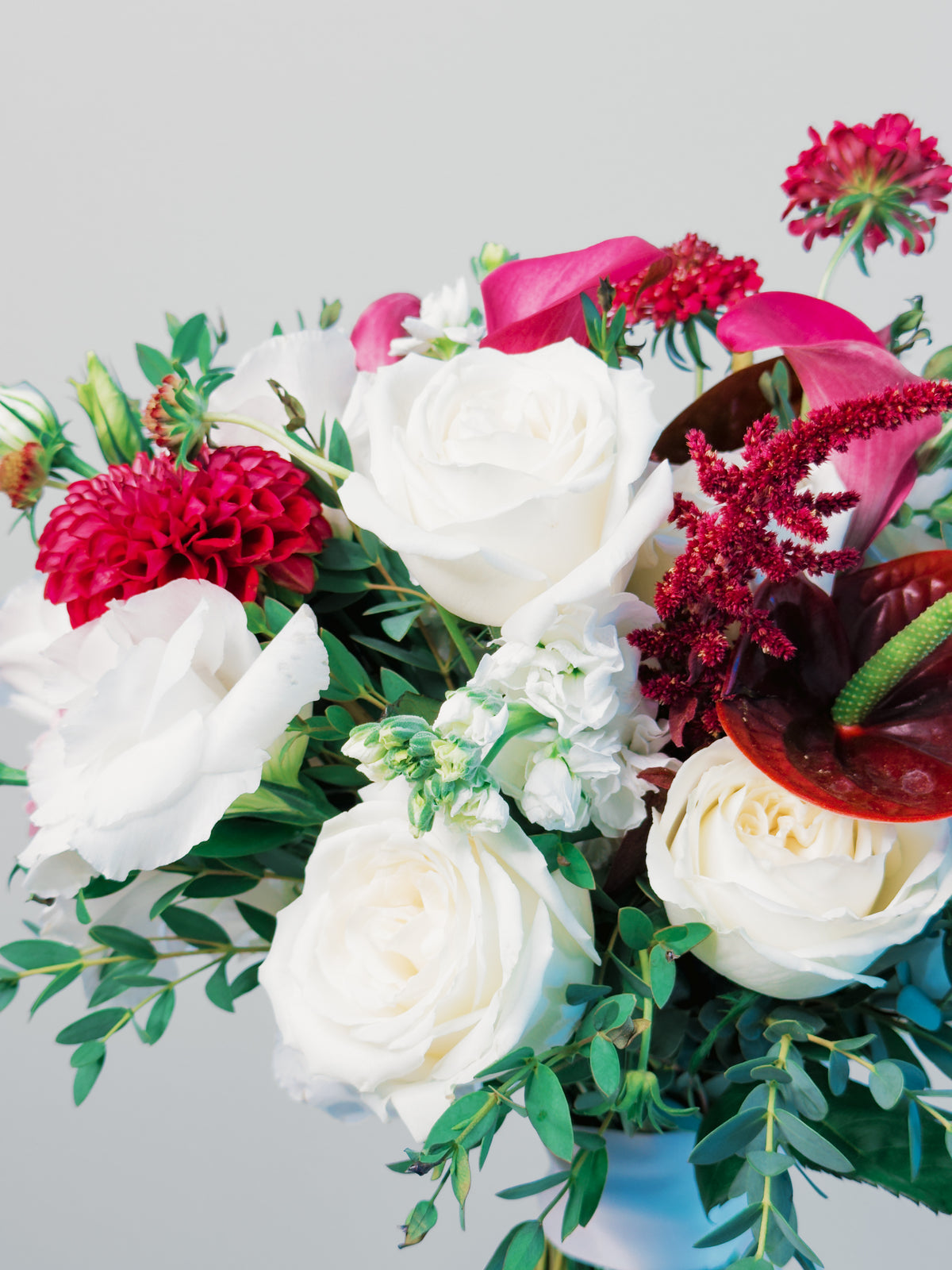 Close-up of Passion Promise with ivory roses, a burgundy dahlia, mauve calla lilies and dark anthurium | Zelena Flora | Los Angeles