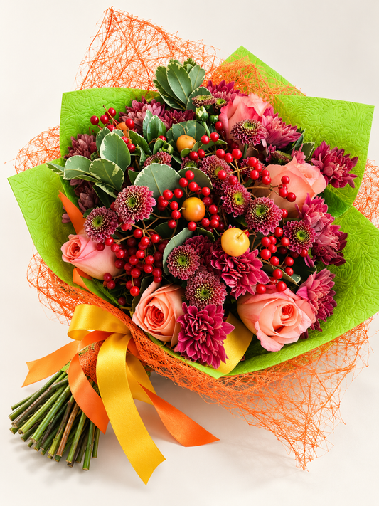 Raspberry Heart hand-tied bouquet in lime-green paper and orange mesh with peach roses, burgundy chrysanthemums and red berries