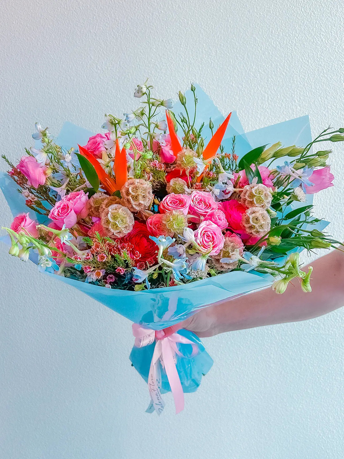 Malibu Magic bouquet with peach-coral roses, pink spray roses, blue delphinium, lavender hydrangea, and greenery | Zelena Flora | Los Angeles